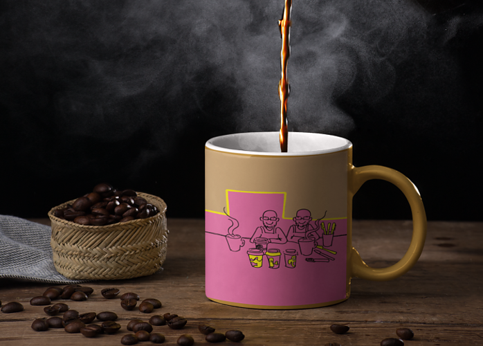 A mug with identical twins on the mug. Sitting on a table with a small basket of coffee beans