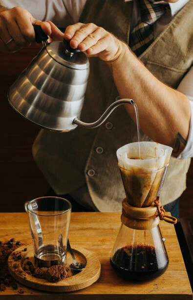 man pouring over the gooseneck kettle over the chemex  funnel