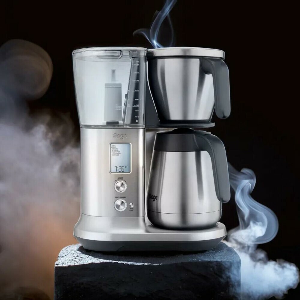 sage drip coffee machine sitting on a rock with steam  in the background