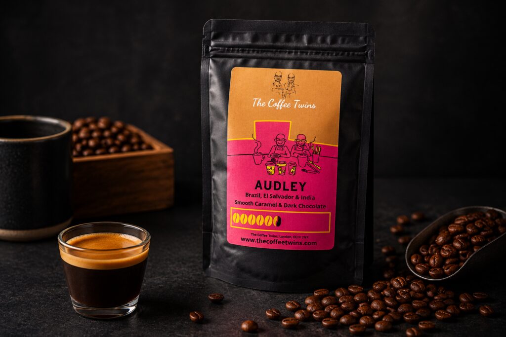 The Coffee Twins Audley speciality coffee blend photographed with an espresso shot and roasted coffee beans. This strong coffee blend combines beans from Brazil, El Salvador, and India, delivering smooth caramel and dark chocolate flavour notes. The image showcases Audley as a premium Father's Day coffee gift and a full-bodied coffee for espresso, moka pot, and cafetière brewing.