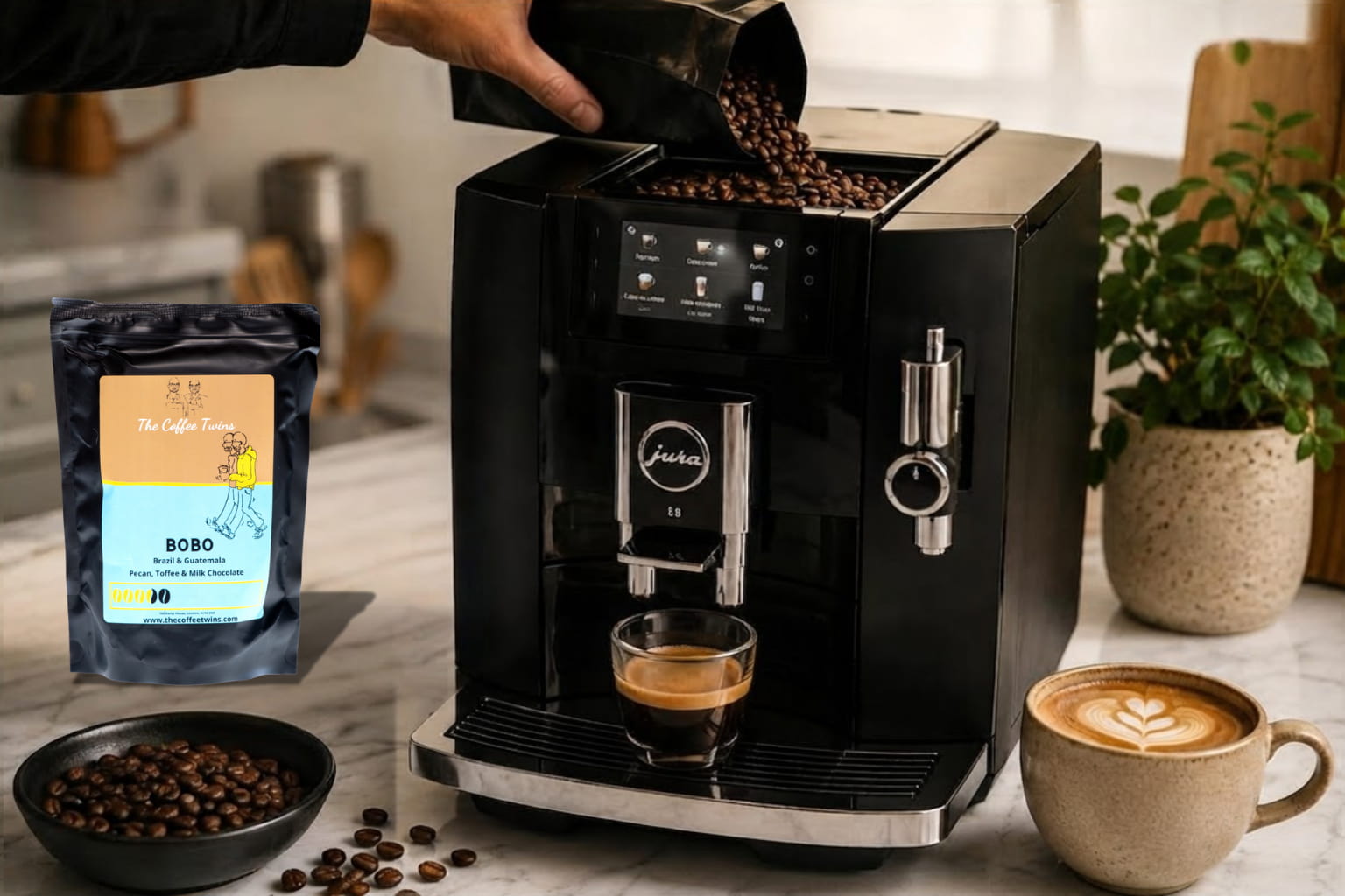 Jura bean-to-cup coffee machine brewing fresh coffee with The Coffee Twins Bobo coffee beans, surrounded by roasted coffee beans and freshly prepared espresso and latte.