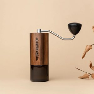 Comandante C40 manual coffee hand grinder with natural wood finish, stainless-steel crank, ergonomic wooden handle and dark glass grounds container.