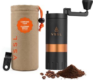 VSSL Java manual coffee hand grinder in black and copper finish, featuring a foldable handle, travel carrying case, cleaning brush and freshly ground coffee.
